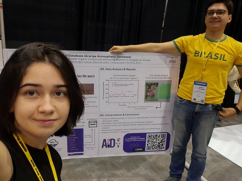 Ludmila e seu orientador, professor Rodrigo Almeida, preparando o banner do A2Database para ser apresentado na maior feira ambiental do mundo - Genius Olympiad 2024